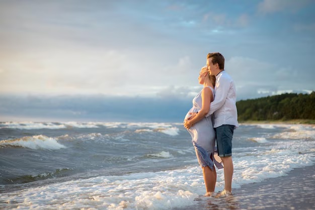 Couple on a beach babymoon in Goa enjoying the sea breeze at golden hour